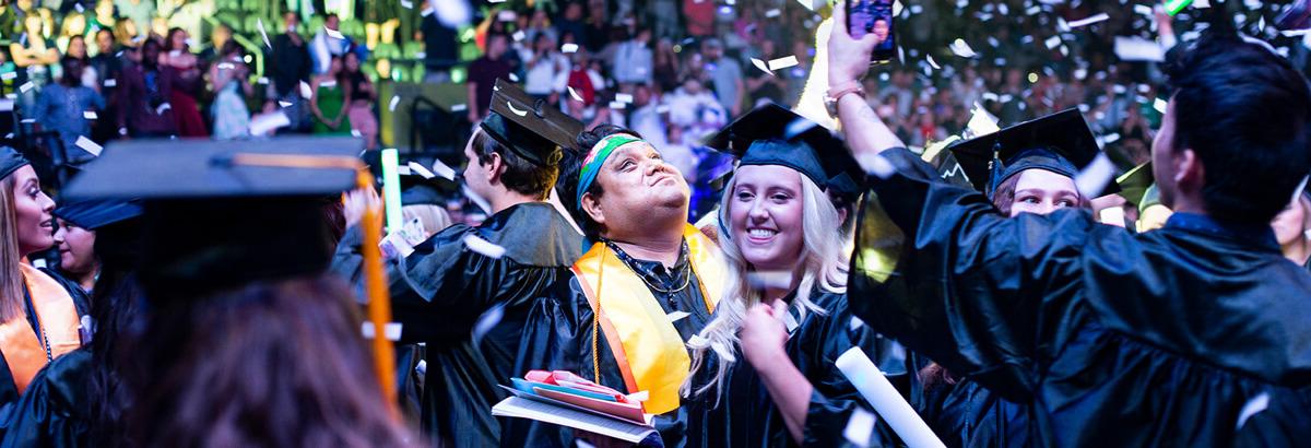 Two Pima Graduates Celebrate at 毕业 while confetti flalls